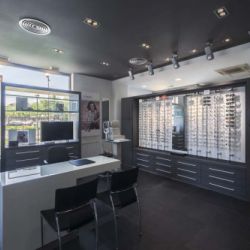 Vista general de la óptica con mesas para atender al cliente en primer término